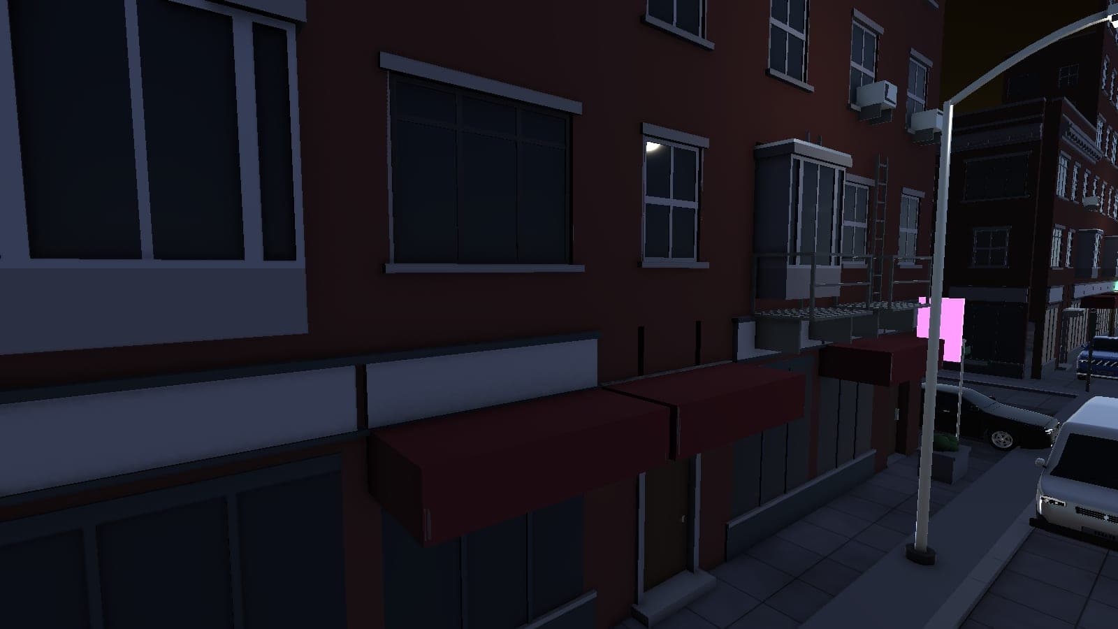 Awnings and shopfronts along a DC26 sidewalk after dark
